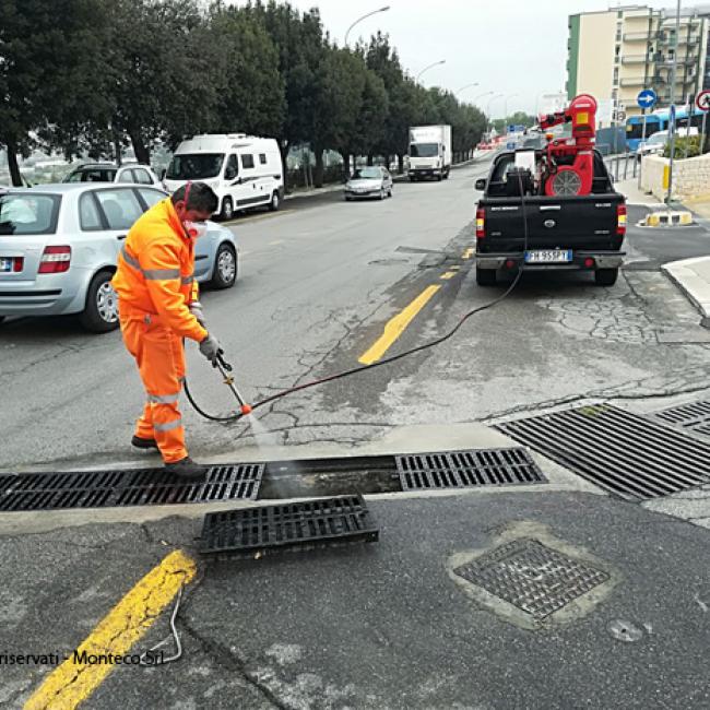 operatore ecologico effettua lavaggio caditoie